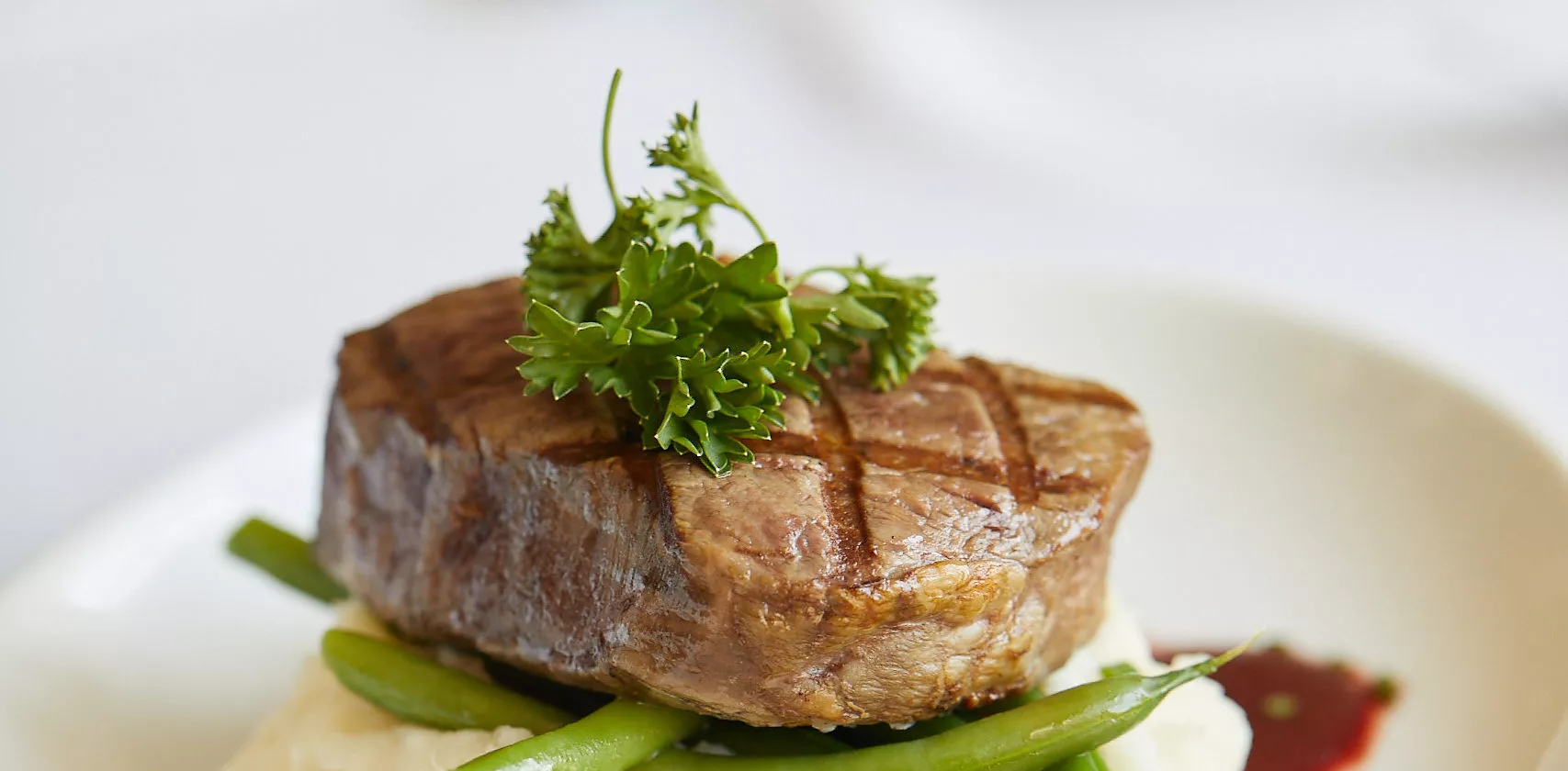 Steak on a mashed potatoes and beans bed