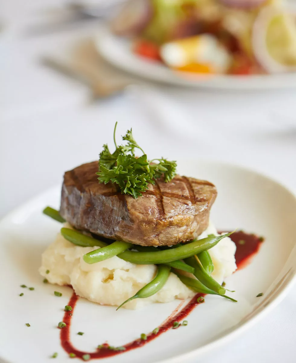 Steak on a mashed potatoes and beans bed