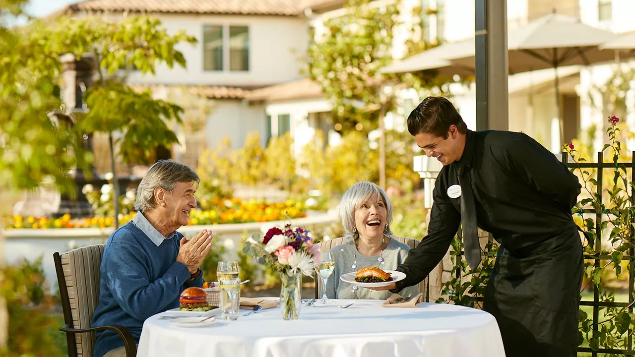 Senior couple is being served by a male waiter