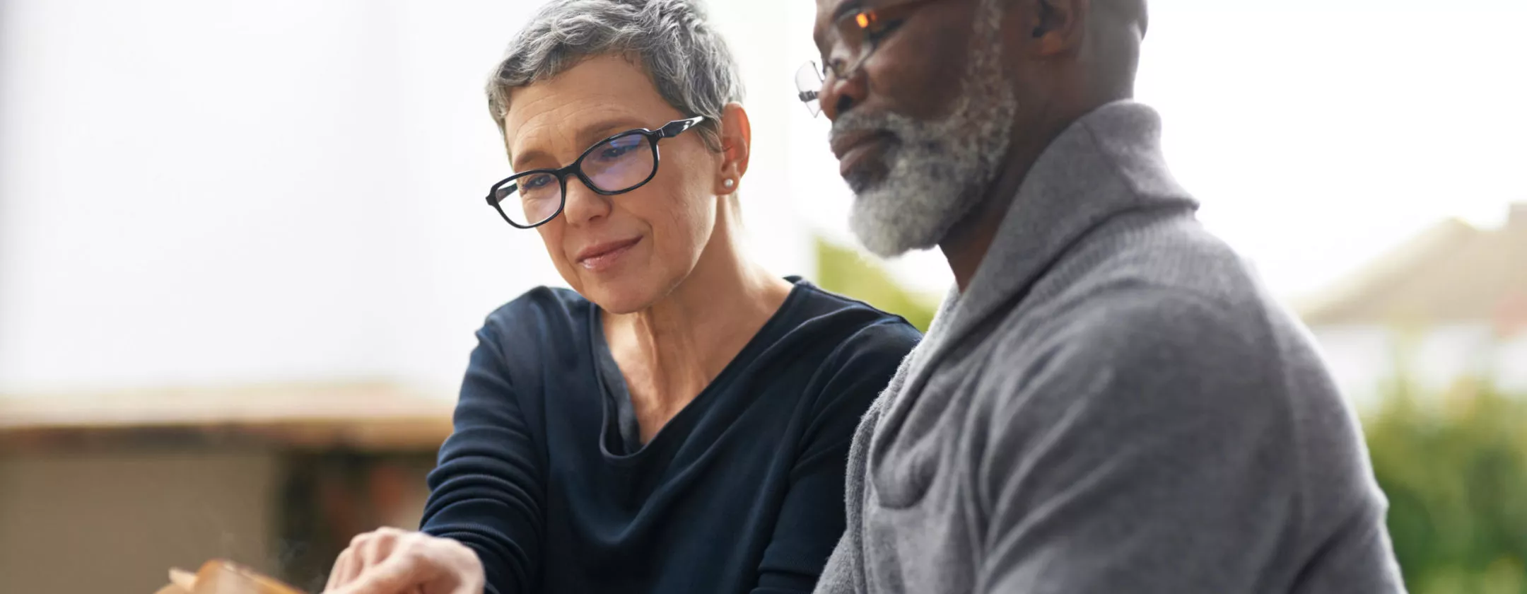 Senior man and woman are reading book together