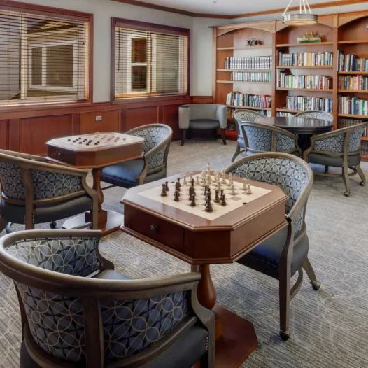 Brookside activity room with chess tables and book shelves
