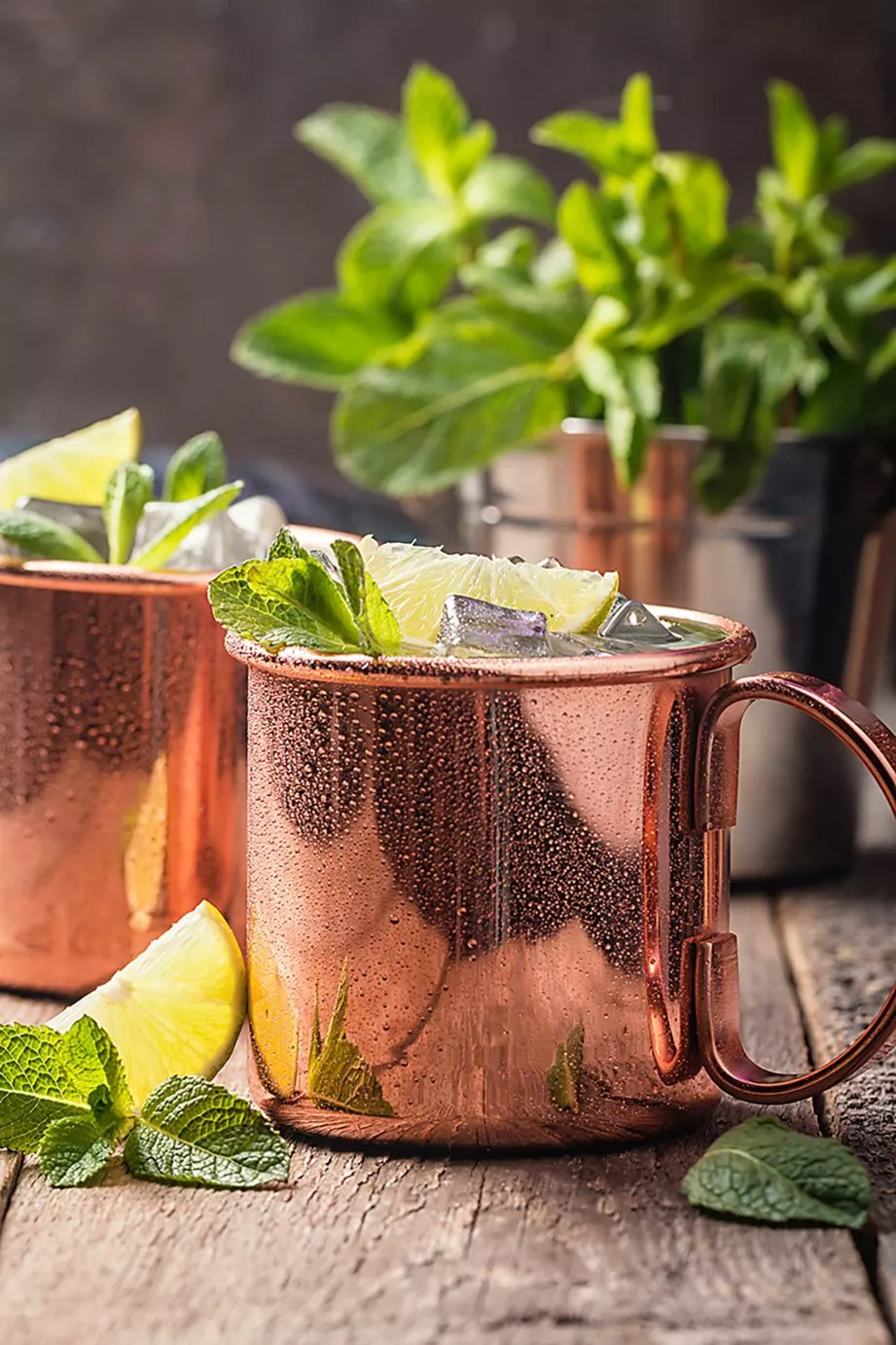 Two cocktails with lime and ice in metallic cups