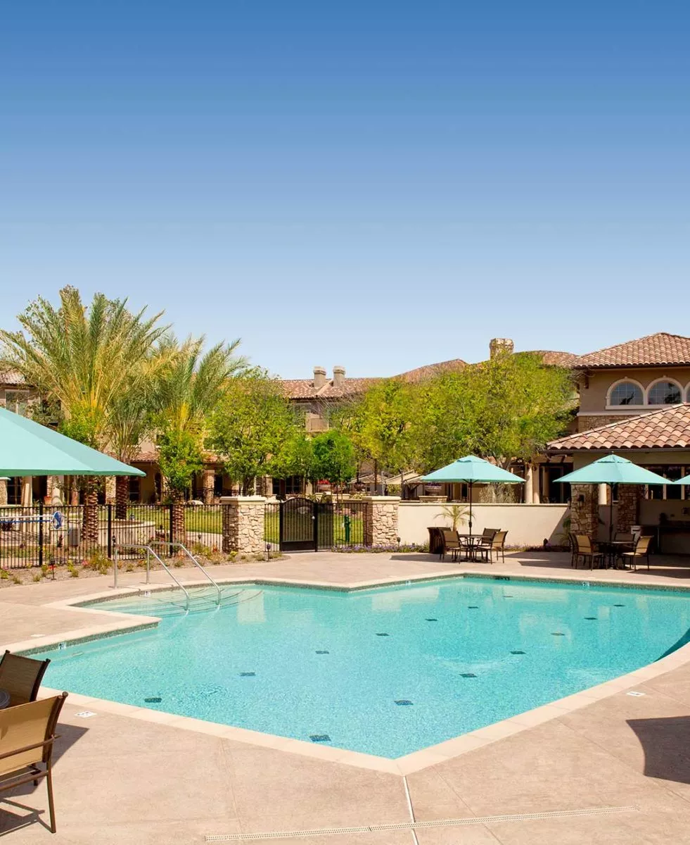 Capriana outdoor pool and patio with blue umbrellas