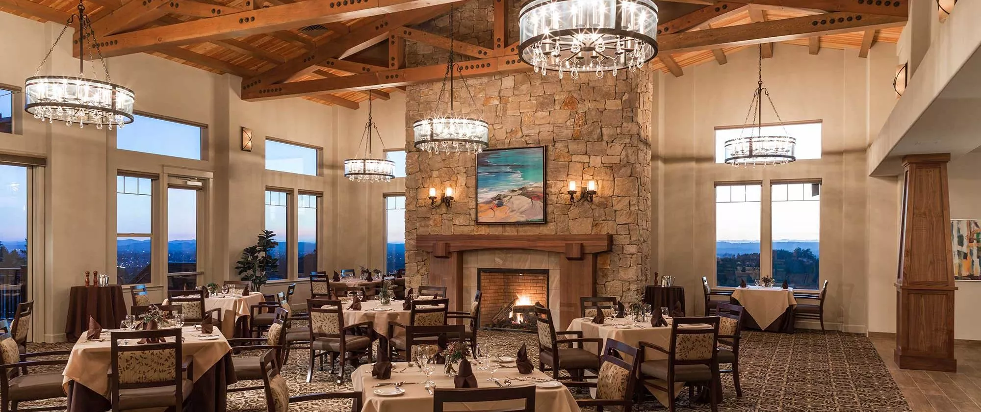 Fountaingrove Lodge dining room with large chandeliers and fire place
