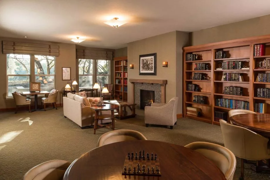 Fountaingrove Lodge activity room with book shelves, seating areas and a chess table