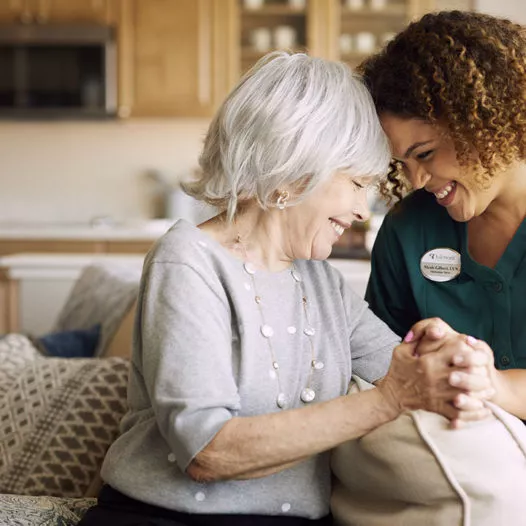 Senior lady and female caregiver are holding hands