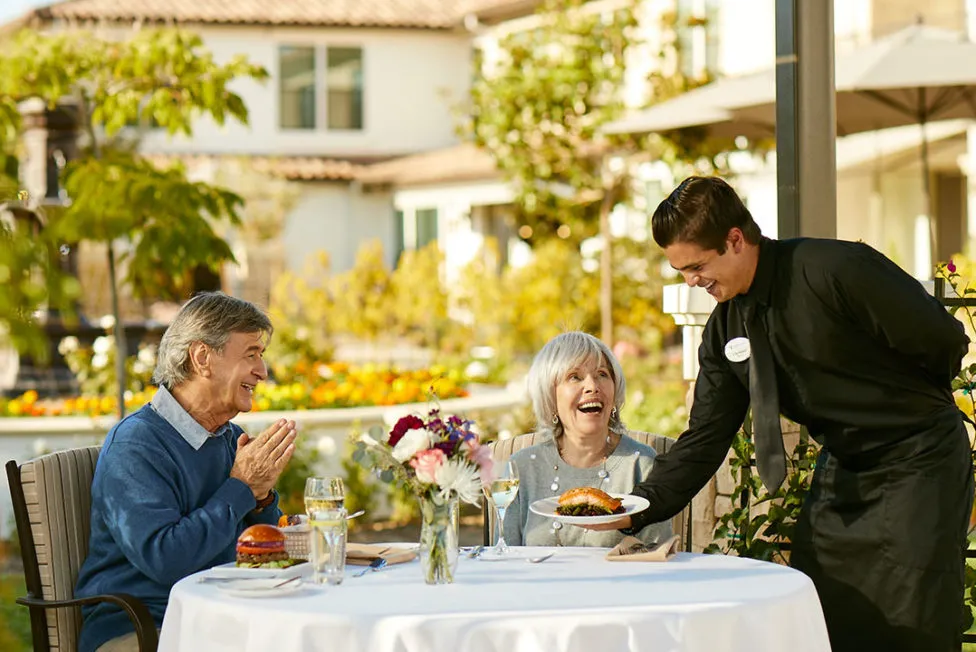 Senior couple is being served by a male waiter