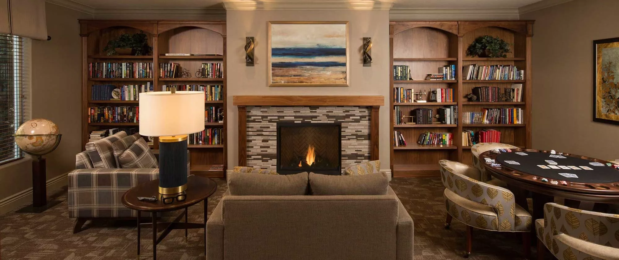 San Jose lounge with sofas, fire place, game table and book shelves