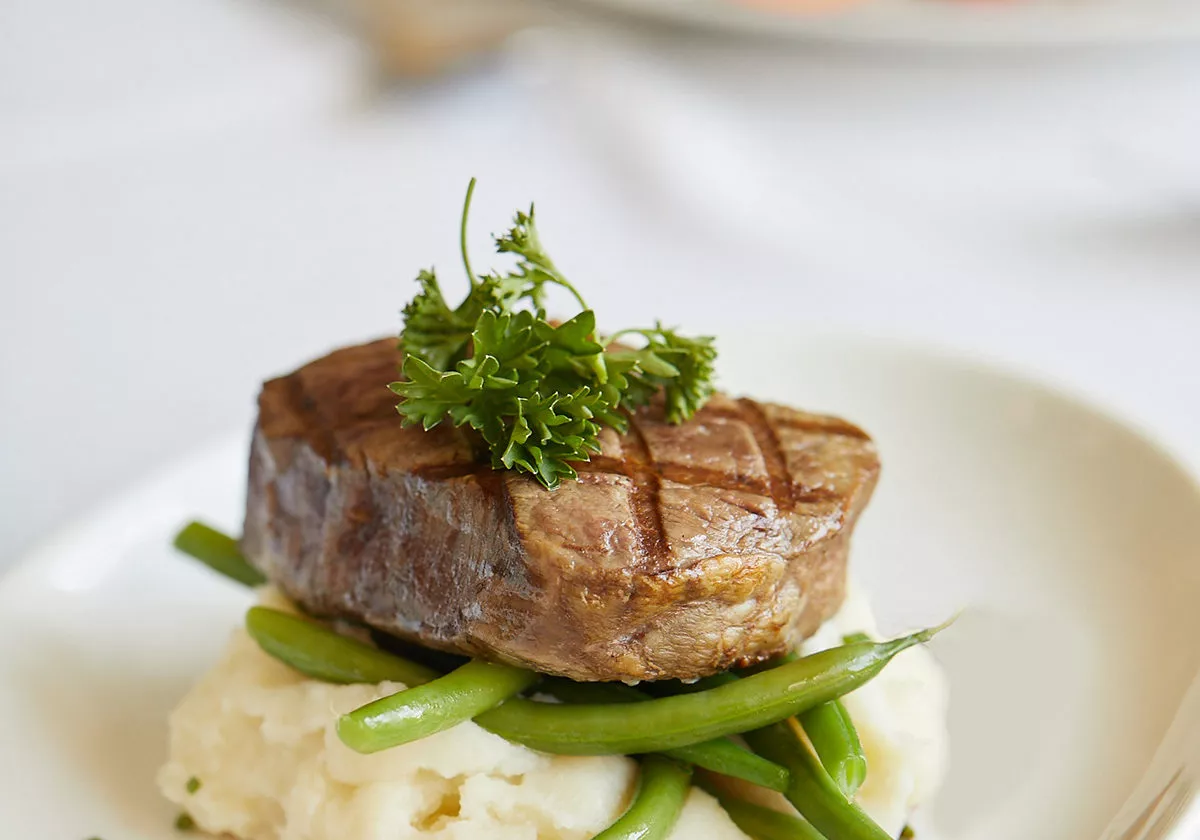 Plate with steak on gourmet mashed potatoes and vegetables