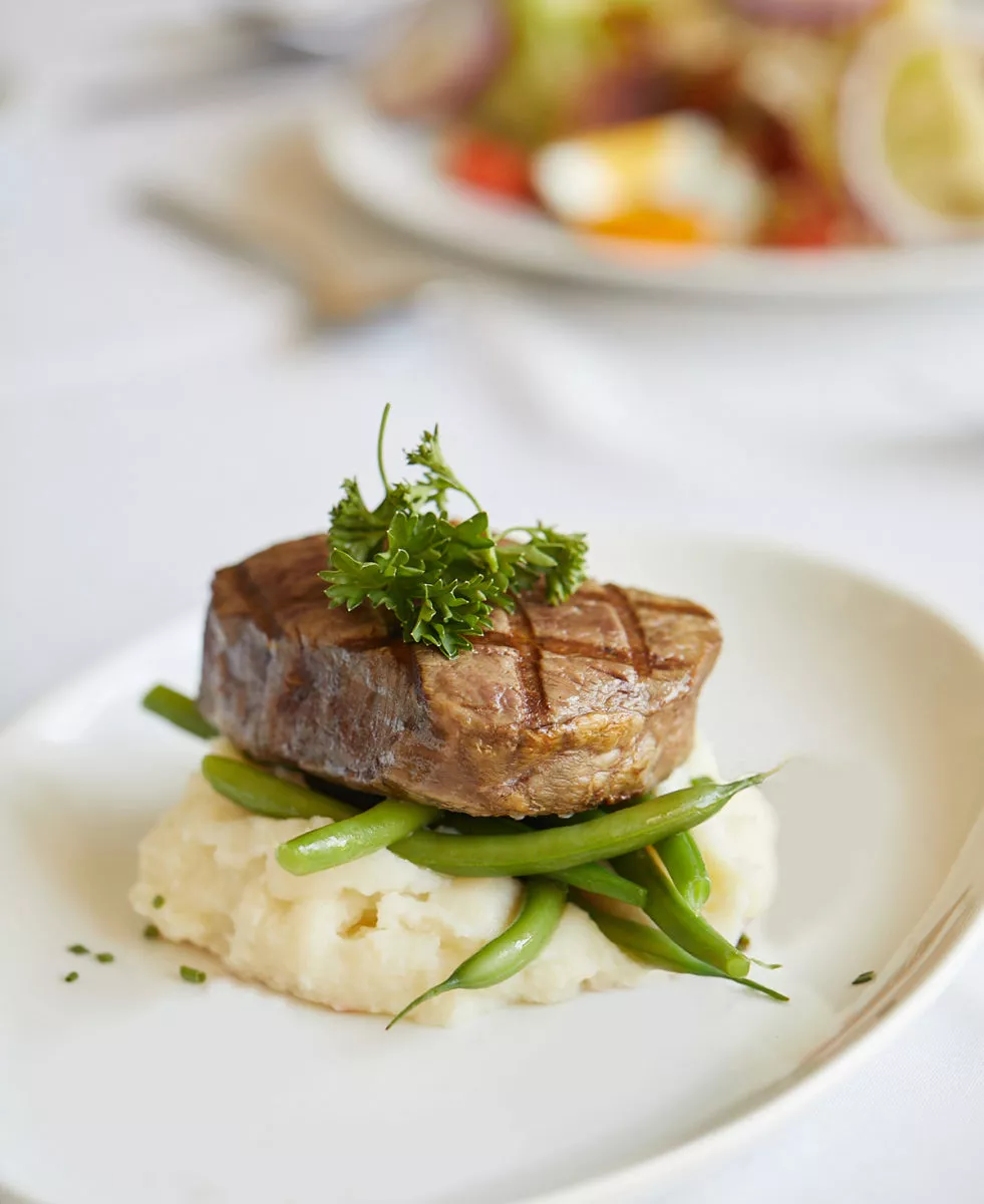 Plate with steak on gourmet mashed potatoes and vegetables