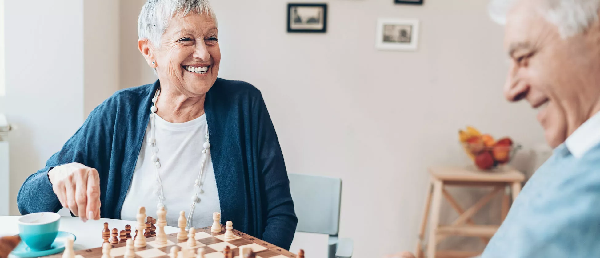 Happy senior couple playing chess at home