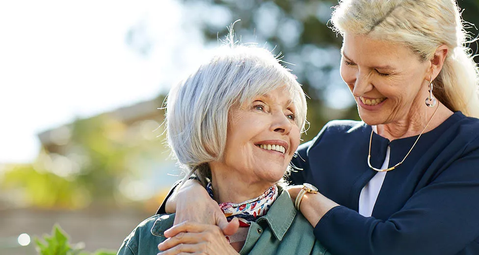 Caregiver is hugging a senior lady