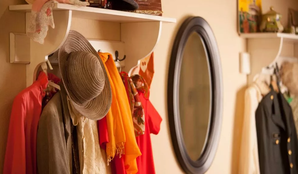 Colourful clothes and a sunhat hanging on wardrobe