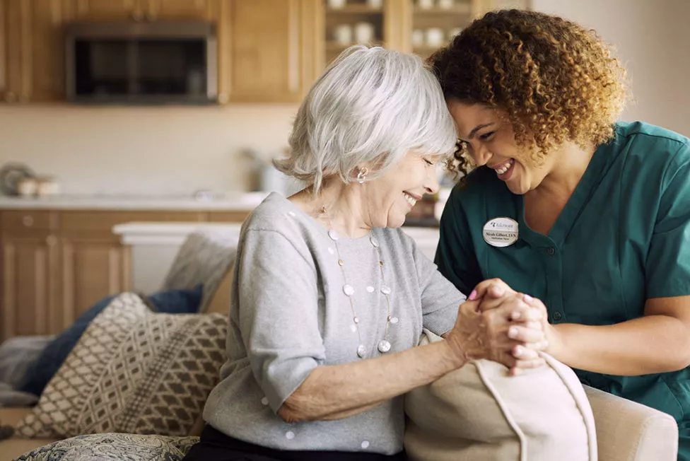 Caregiver is holding senior lady's hand