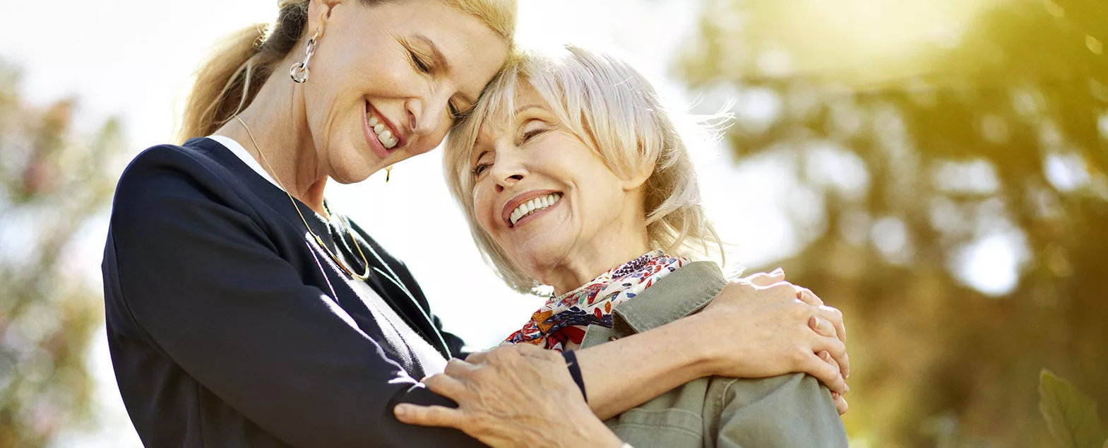 Caregiver is giving a hug to a senior lady