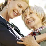Caregiver is giving a hug to a senior lady