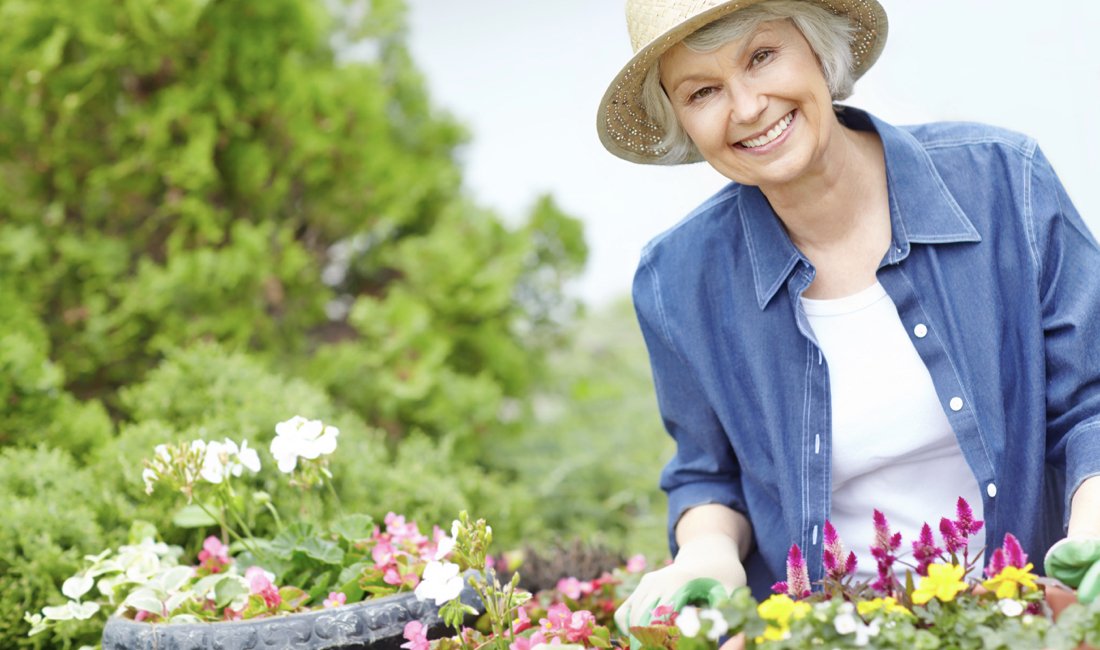 An elderly lady gardening.