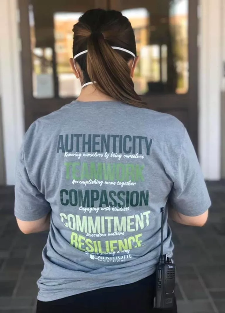 Person wearing a t-shirt printed with words like Authenticity, Compassion, and Committment