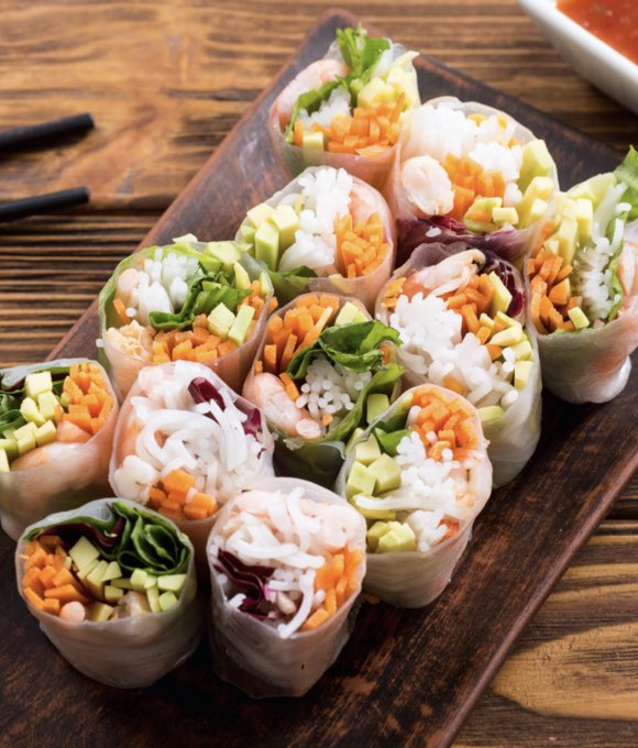 A plate with 12 vegetarian spring rolls.