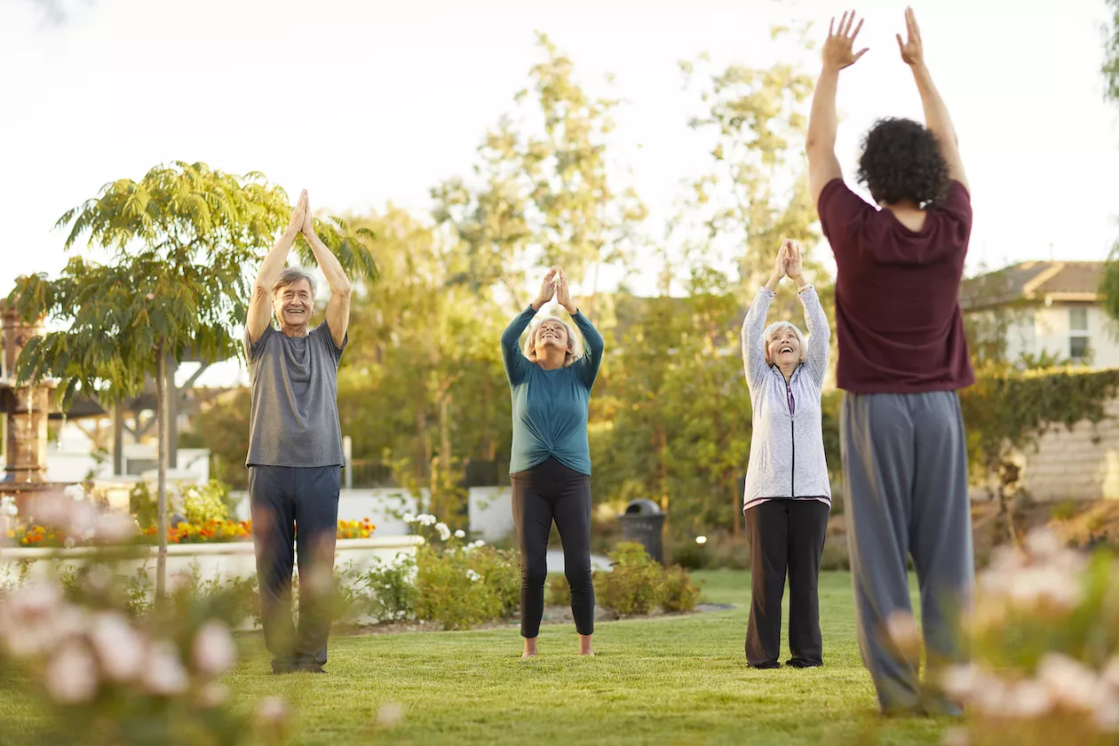 Seniors are doing yoga outdoors at Oakmont