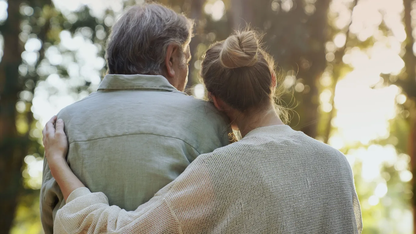 Senior couple hugging outdoors at a luxury senior living community